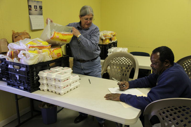 Volunteer Ann Willbrand talks a client through the process of signing up for benefits. Over 45 people volunteer with the DCCM food pantry.