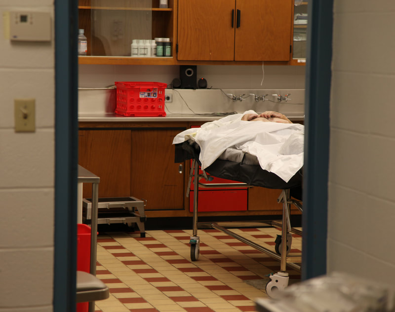 The body of a homeless man lies on a gurney in the city-county morgue. Any person who dies without the financial means for burial may be eligible for interment at the local paupers' cemetery. 